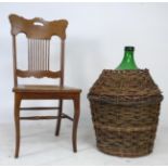 An American large wicker bound green glass demijohn bottle, together with an American oak chair with