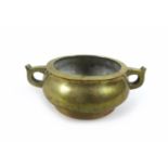 A Chinese polished bronze censor, of twin handled squat circular form, raised on a high foot rim,