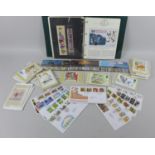 A collection of Royal Mint Stamps, commemorative coins and postcards, including a limited edition,