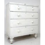 A Victorian white painted chest of two over three graduating drawers, with turned handles and
