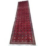 A Turkman runner, with red ground and multiple guls to field, narrow borders, 295 by 83cm.