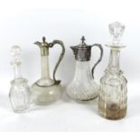 A group of cut glass decanters, comprising a claret jug with silver plated mounts, fruiting vine