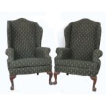 A pair of modern wingback armchairs, in Queen Anne style, upholstered in dark green and gold fleur