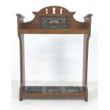 An Arts and Crafts oak stick stand, with decorative inlaid copper plaque, pierced decoration,