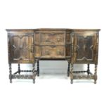 A Jacobean style oak sideboard, mid 20th century, with two central shaped drawers flanked by two