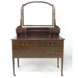 An Edwardian mahogany dressing table, with arched rectangular mirror, trinket drawers, over two