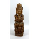 An Indonesian carved wooden deity statue, mid 20th century, modelled in sitting pose with cross legs