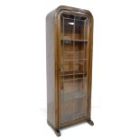 An early 20th century oak book case, featuring an arched top, a single leaded glazed door, with