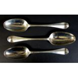 A collection of three George II silver Hanoverian pattern table spoons, comprising one by Samuel