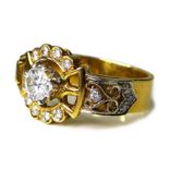 An 18ct gold and diamond ring of ornate buckle design, the central brilliant cut diamond of