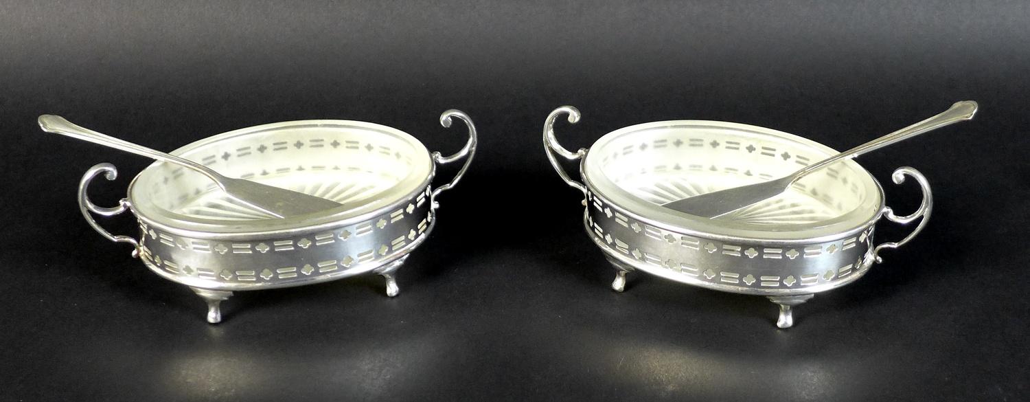 A pair of Elizabeth II silver butter dishes with matching butter knives, of oval form with with twin