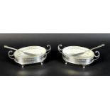 A pair of Elizabeth II silver butter dishes with matching butter knives, of oval form with with twin