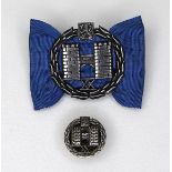 A Finnish silver heraldic pin, the symbol relating to the ancient city of Turku, set on a blue