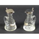 A pair of Edwardian clear glass and silver mounted noggin flasks, each of tapering form with mounted