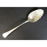 A George III silver serving spoon, with scalloped bowl and engraved decoration to handle,