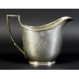 A George III silver milk jug, of helmet form with reeded rim and handle decoration, monogram