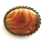 A 19th century fire banded agate brooch, of polished oval form, in an unmarked 14ct yellow gold