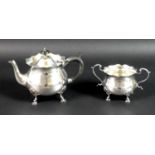An Edward VII silver teapot and sugar bowl, of bombe form with scalloped rims, raised on four