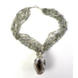 A geode and moss agate necklace, the agate geode with calcite crystal interior, and having natural