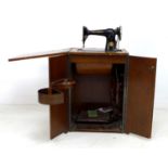 An early to mid 20th century Singer sewing machine, serial EG298785, in a fitted walnut veneered