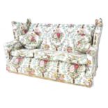 A Knowle style three piece suite, in floral pattern upholstery, comprising a three seater sofa