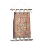 An Iranian nomadic tribal cradle, leather and embroidered with four boteh around a central