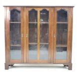 A mid 20th century mahogany glazed bookcase, with three glazed doors each enclosing two adjustable