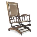 An American Rocker with stained turned supports, and upholstered seat and back, 58.5 by 73 by