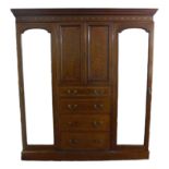 An Edwardian mahogany compactum wardrobe, with inlaid and crossbanded decoration, outswept cornice