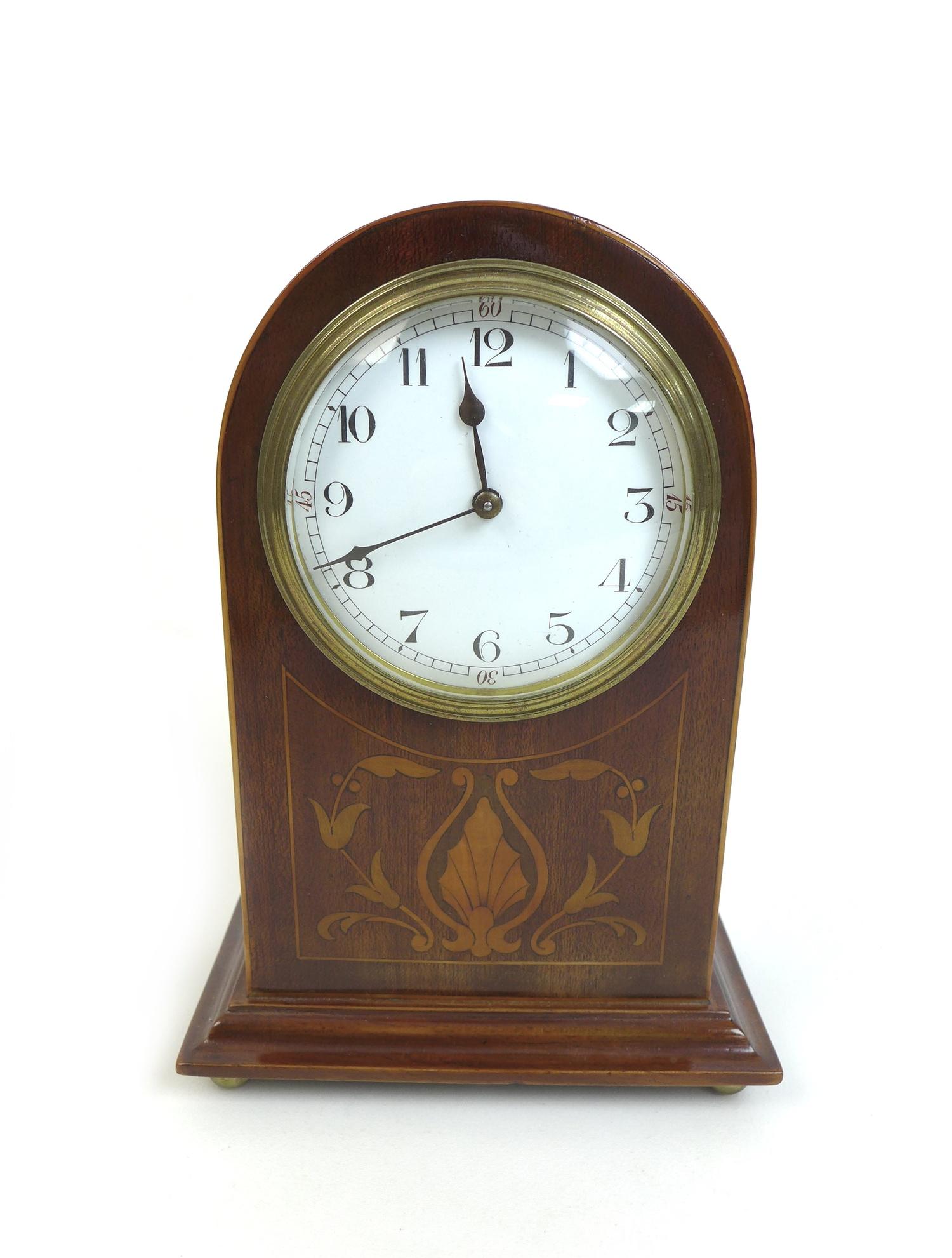 An Edwardian mahogany mantle clock, the domed topped case with decorative marquetry inlay, white