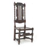 An oak Jacobean style hall chair, early to mid 20th century, with carved frame, decorative crown