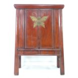 A modern Chinese style cabinet, of tapering form with red lacquered finish, brass butterfly shaped