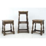 Three 1920s oak stools, comprising a pair, 35 by 40.5 by 77cm high, and taller single stool, 31 by
