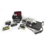 A group of vintage cameras and camcorders, including a Polaroid Instamatic camera, some with