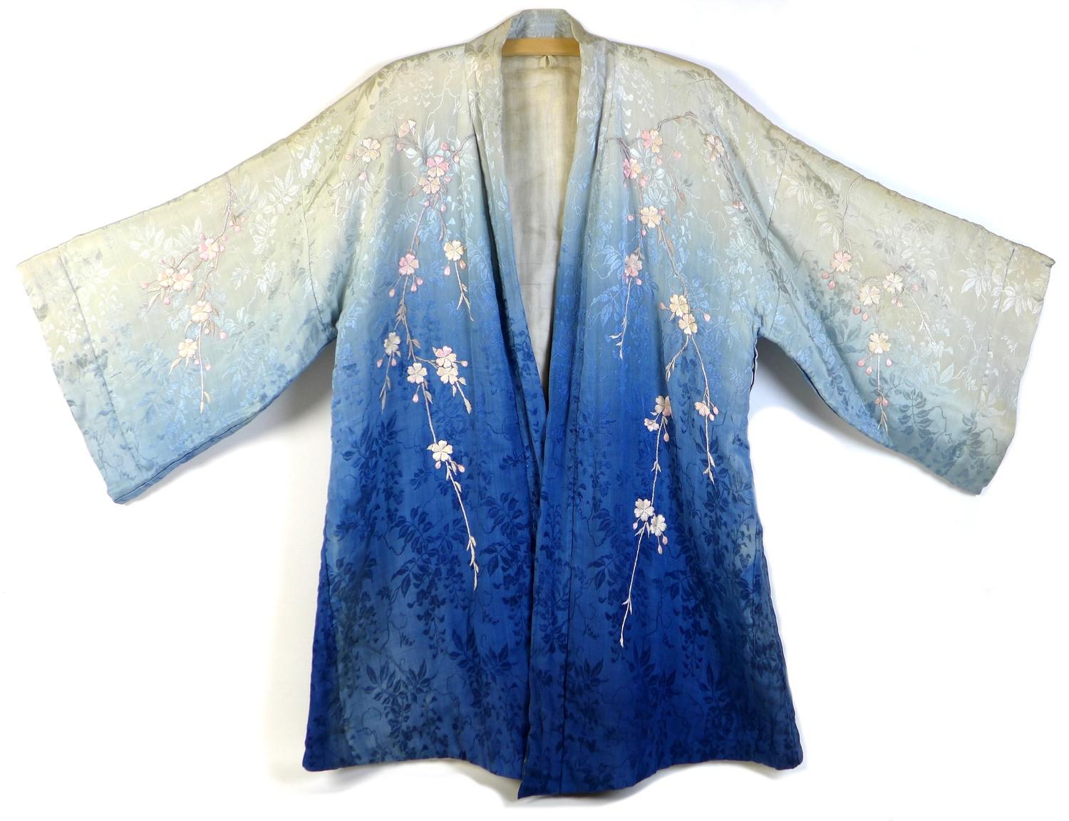 An early 20th century Japanese haori padded jacket, embroidered in silk with white and pink flowered