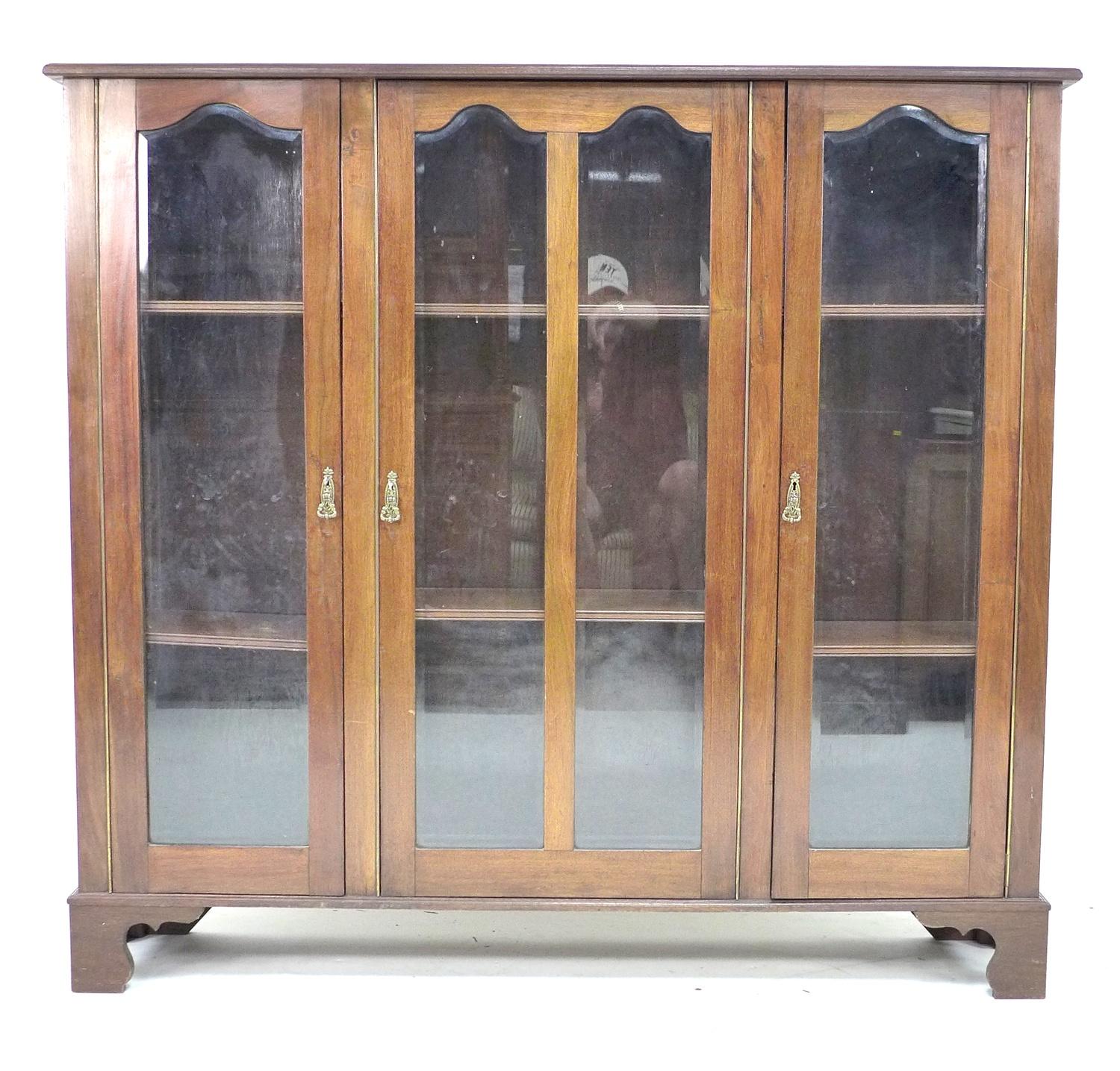 A mid 20th century mahogany glazed bookcase, with three glazed doors each enclosing two adjustable