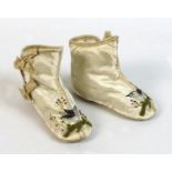 A pair of Edwardian baby's boots, circa 1900, leather soles and cream silk, with two bows to the