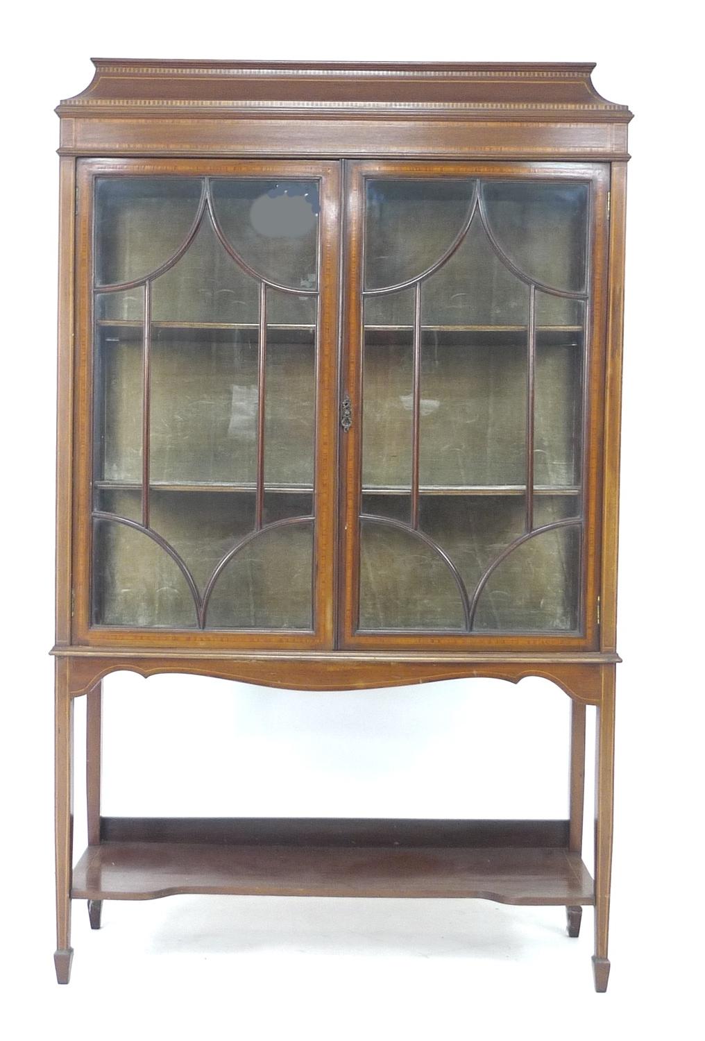 An Edwardian mahogany crossbanded and line inlaid display cabinet, twin glazed doors enclosing two