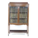 An Edwardian mahogany crossbanded and line inlaid display cabinet, twin glazed doors enclosing two