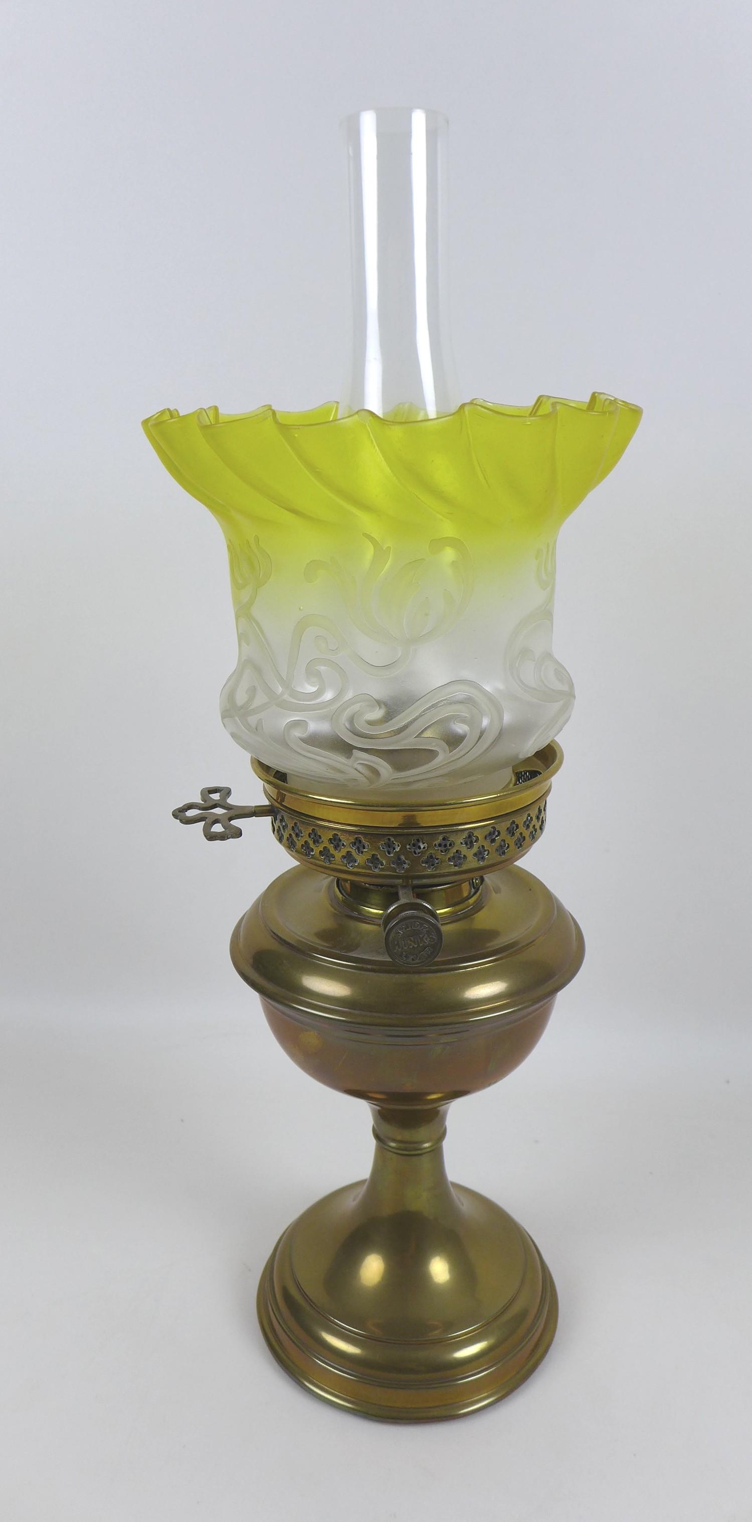 Two Victorian brass paraffin lamps, each with a brass reservoir on