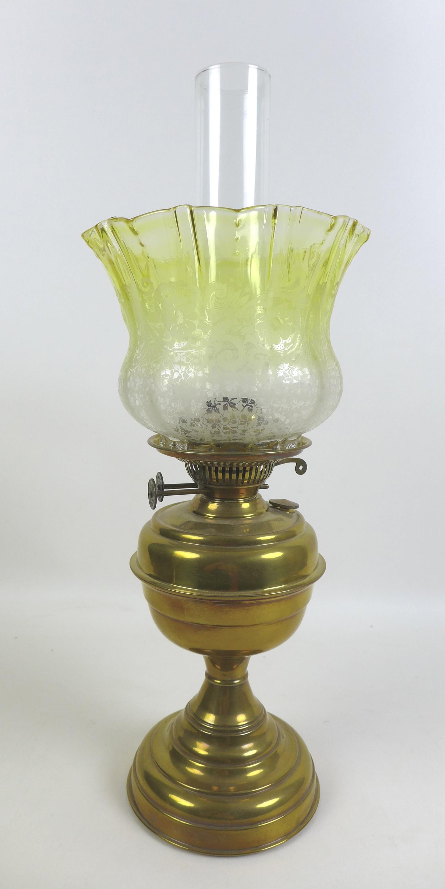 Two Victorian brass paraffin lamps, each with a brass reservoir on