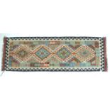 A vegetable dyed wool Choli Kelim runner, with four large diamond medallions to the field and