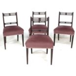 A set of four Regency mahogany dining chairs, each with pierced decoration to top rails, upholstered