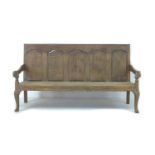 A late 18th century oak settle, with five section panelled back, shaped arm rests, raised on