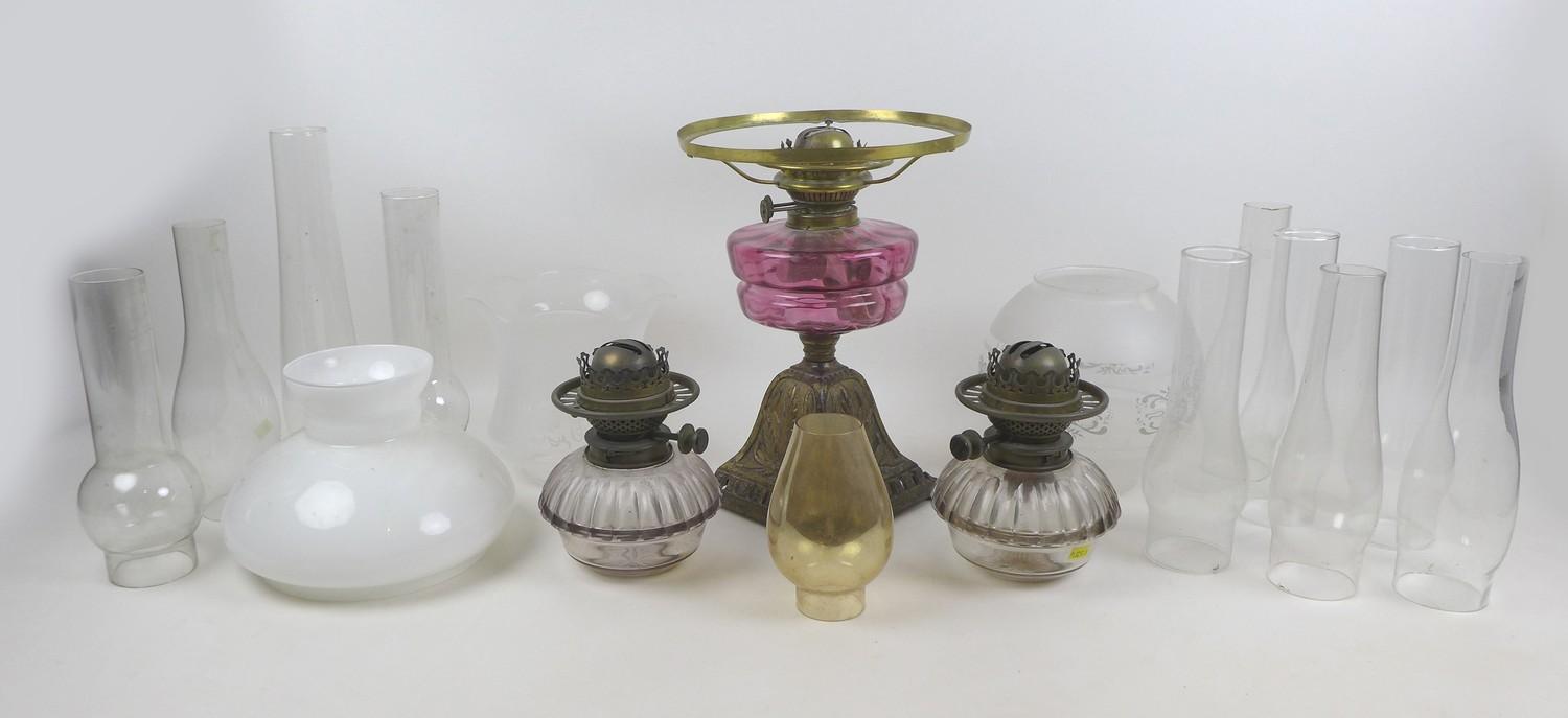 A Victorian paraffin lamp, with cranberry glass reservoir, etched clear glass shade and chimney,