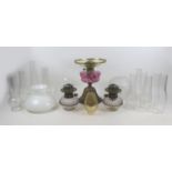 A Victorian paraffin lamp, with cranberry glass reservoir, etched clear glass shade and chimney,
