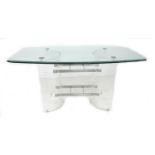 A modern design dining table, shaped rectangular clear glass surface with bevelled edge raised on