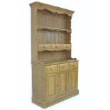 A modern small pine dresser, with plate rack above three drawers and three doored cupboard, 107 by