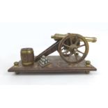 A mid 20th century brass and oak model canon on stand, overall 31 by 17 by 13cm high.