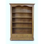 A modern French oak veneered freestanding bookcase, with four adjustable shelves and two drawers